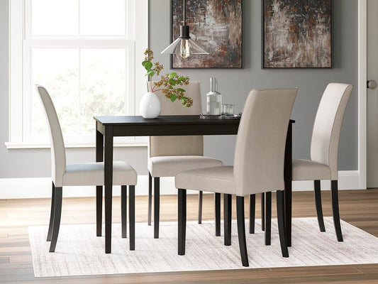 A modern dining room featuring the Kimonte Rectangular Dining Room Table in dark brown, four beige upholstered chairs, a white vase with greenery, glassware, and two abstract paintings on a gray wall.