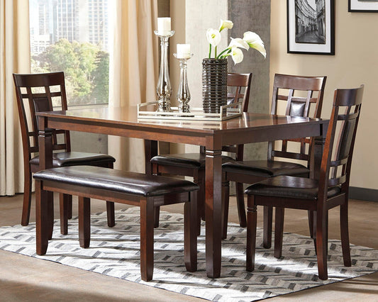 A modern dining room featuring the Bennox Dining Room Table Set (6/CN) with a dark wood table, four upholstered chairs, a bench with black cushions, and a decorative centerpiece on a geometric rug.