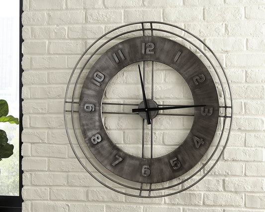 The Ana Sofia Wall Clock, a large metal round clock with a rustic finish and open center, is shown mounted on a white brick wall, displaying the time as 10:11.