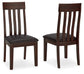 The image shows two Haddigan Dining UPH Side Chairs (2/CN) with a dark brown wood finish, vertical slat backs, and black faux leather upholstered seats—one chair is front-facing, the other angled.