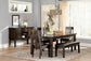 A modern dining room with a dark wood table, bench, sideboard, abstract wall art, large windows with light curtains, and four Haddigan Dining UPH Side Chairs featuring cushioned upholstered seats.