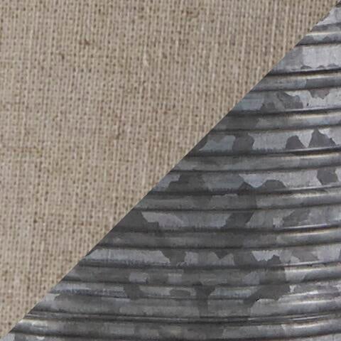 Diagonal split image features beige woven fabric texture on the top left and corrugated gray metal surface—evoking the design of the Norbert Metal Table Lamp (2/CN)—on the bottom right.