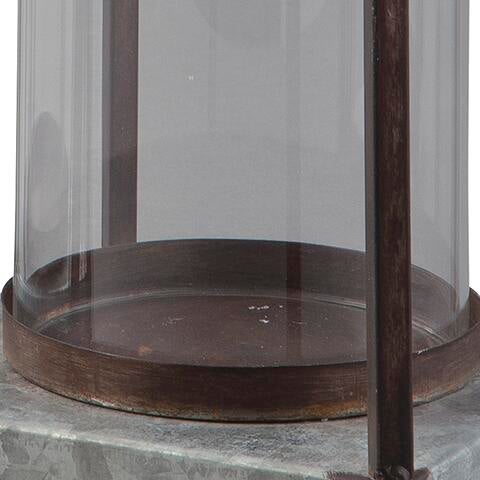 A close-up of the Diedrick Lantern Set (2/CN) base shows its galvanized metal, supporting rod, and metal rim, resting on a stone surface.