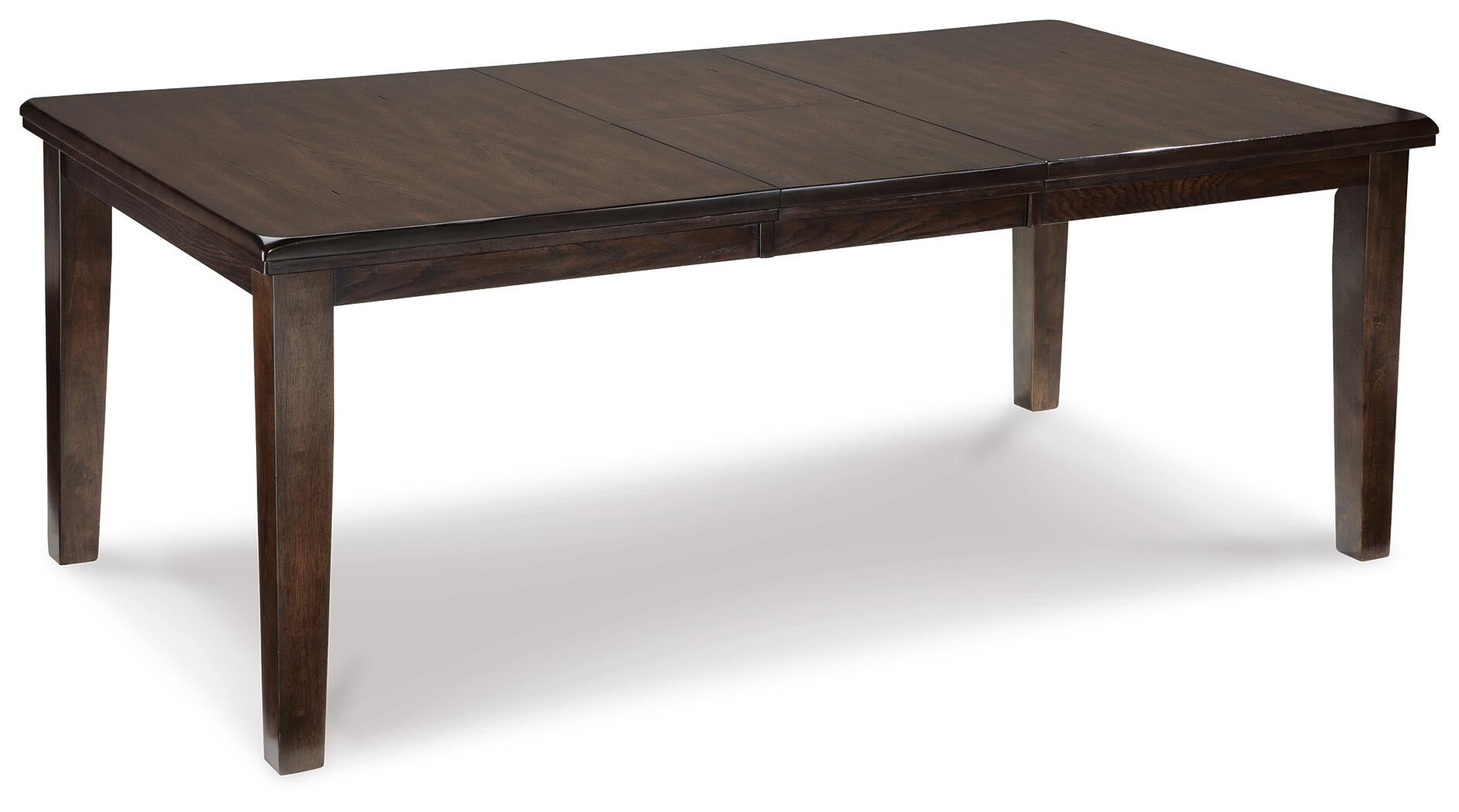 The Haddigan RECT Dining Room EXT Table is a rectangular dark wood farmhouse table with four legs, a smooth surface, and a butterfly leaf extension. Shown on a white background, it seats up to 8 for versatile gatherings.