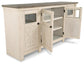The Bolanburg Extra Large TV Stand features a two-tone farmhouse design with a white wooden base, dark top, two glass-paneled doors, and interior shelves, shown open.