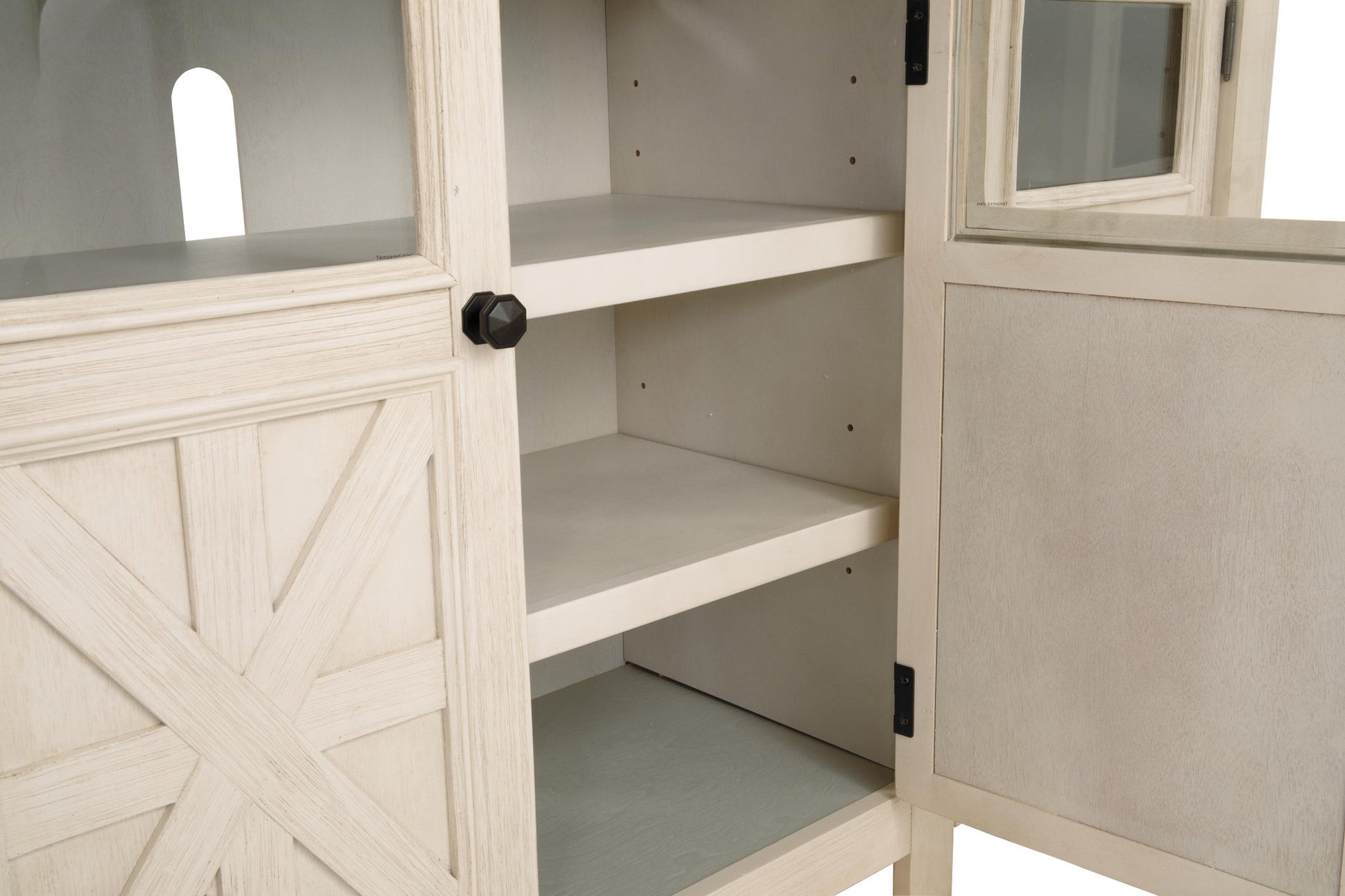 A close-up of the Bolanburg Extra Large TV Stand shows its open white wooden cabinet with two shelves and a partially open door featuring a black knob.