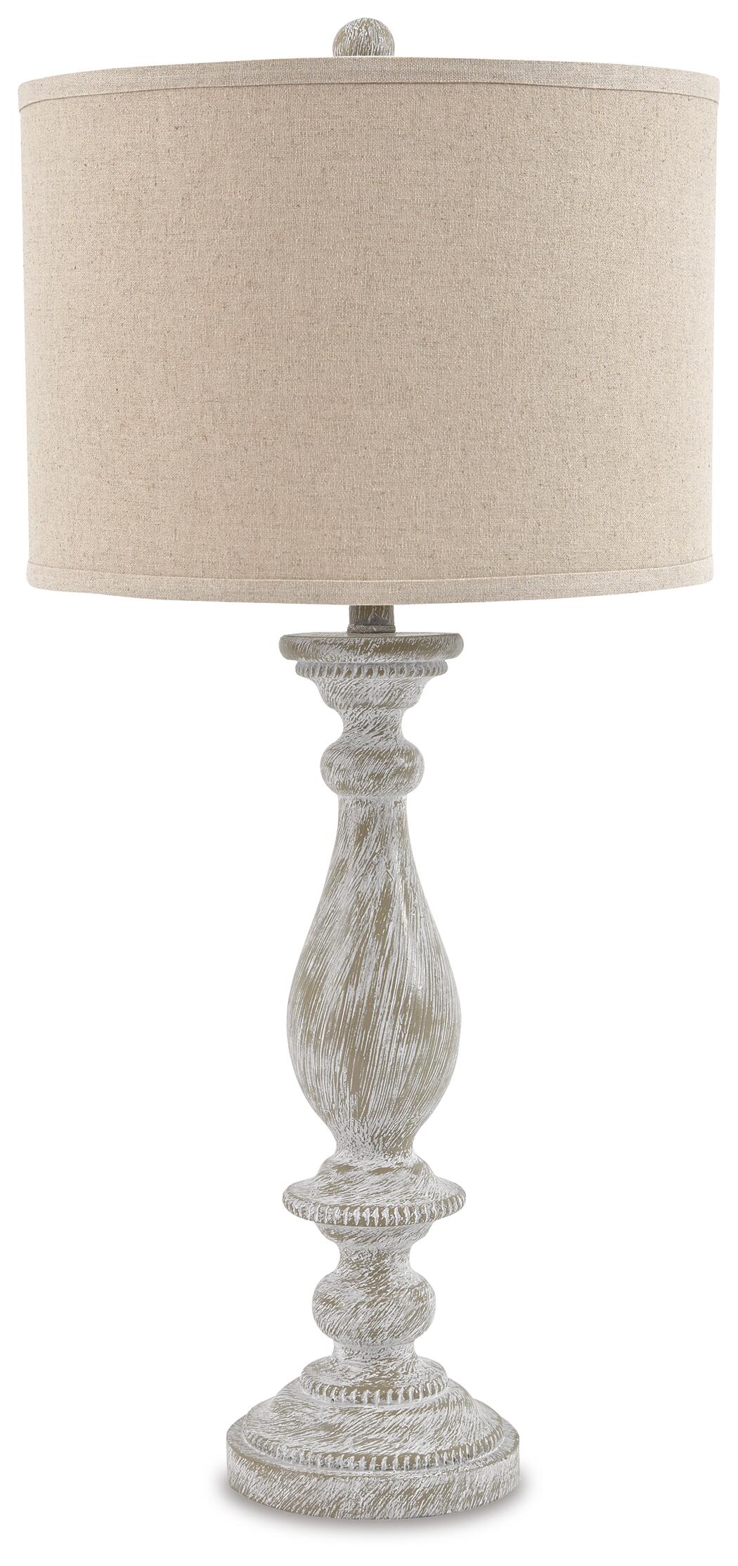 The Bernadate Poly Table Lamp (2/CN) features a beige drum shade, a textured base with a distressed whitewash finish, and ornate candlestick-style detailing.
