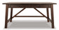 The Baldridge Home Office Large Leg Desk features a dark rustic finish, two drawers with metal handles, and a sturdy crossbar support—ideal for adding industrial style and function to any home office.