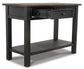 The Tyler Creek Sofa Table features black wood, traditional hardware, one open drawer, and a lower shelf, displayed against a white background.