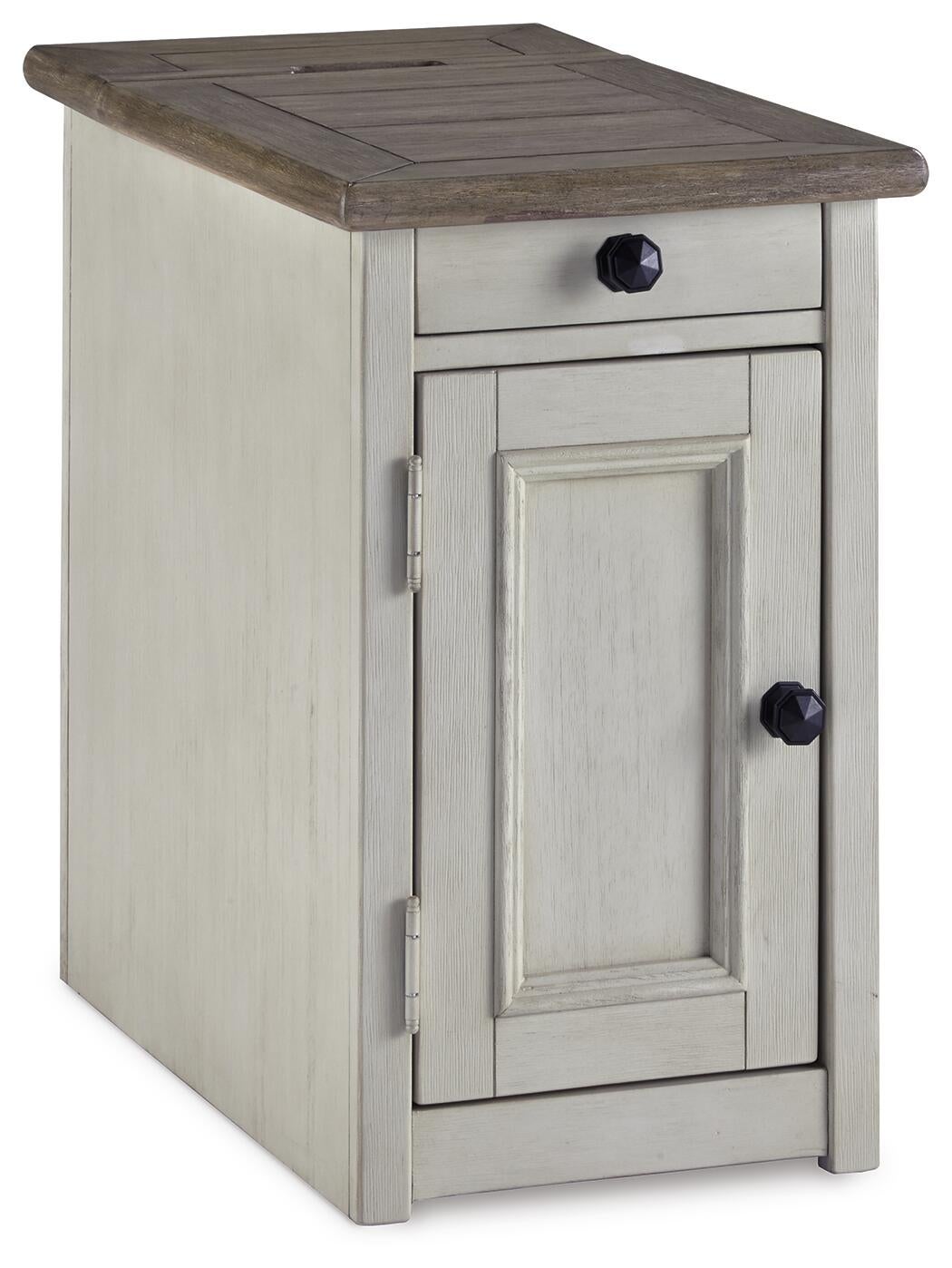 The Bolanburg Chair Side End Table is a small, rectangular table in antique white with a single drawer, cabinet door, black round knobs, and built-in USB ports.