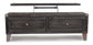 The Todoe Lift Top Cocktail Table is a dark wood TV stand with a spring-lift top, two drawers, and a lift-up panel that reveals roomy internal storage.