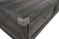 Close-up of the Todoe Lift Top Cocktail Table's dark wood drawer corner, featuring a metal corner protector and round handle in rustic-industrial style, isolated on a white background.