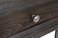 Close-up of a dark wood drawer with a metallic round knob handle, part of the Todoe Rectangular End Table—a rustic-industrial piece that blends modern design details.