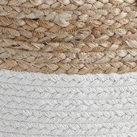 Close-up of the Sweed Valley Pouf, a woven basket-style pouf with natural tan fibers on top and white fibers on the bottom.