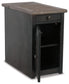 The Tyler Creek Chair Side End Table features a weathered gray-brown finish, dark wood accents, one top drawer, and a lower cabinet door that opens to an interior shelf for added storage.