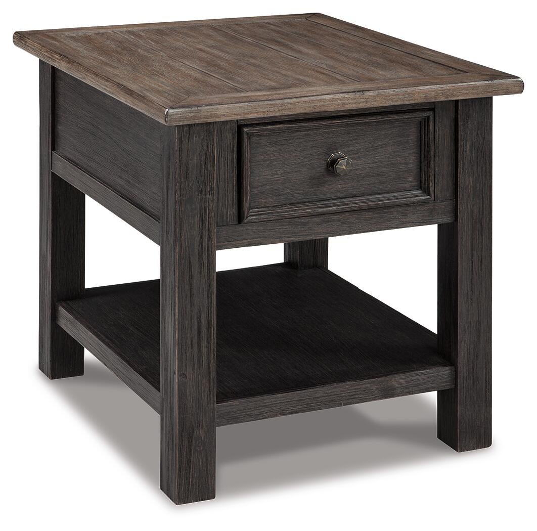The Tyler Creek Rectangular End Table features a dark solid wood frame, weathered gray-brown top, single drawer, lower shelf, and straight legs—perfect for adding stylish shabby chic charm to any space.