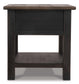 The Tyler Creek Rectangular End Table features a weathered gray-brown solid wood top, straight legs, a smooth surface, and an open lower shelf for extra storage.