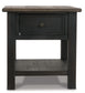 The Tyler Creek Rectangular End Table features a dark wood finish, weathered gray-brown top, single drawer, and open lower shelf—an elegant solid wood accent piece displayed against a white background.