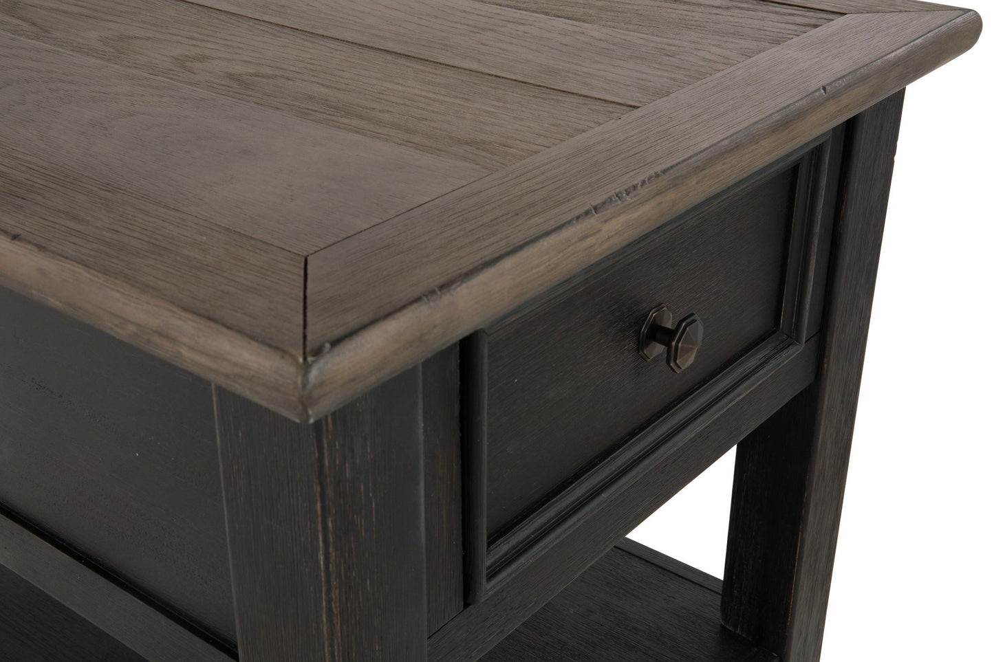 Close-up of the Tyler Creek Rectangular End Table, featuring a single drawer and shelf, weathered gray-brown top, dark finish, and visible wood grain.
