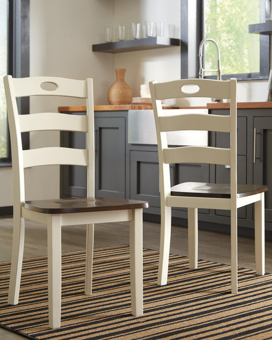 Two Woodanville Dining Room Side Chairs with cream frames and dark brown seats sit on a striped rug in a kitchen featuring gray cabinets and a window.