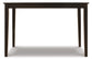 The Kimonte Rectangular Dining Room Table features a contemporary dark brown finish, a rectangular shape, and four straight legs, shown against a white background.