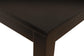 Close-up of the Kimonte Rectangular Dining Room Table’s dark brown corner with clean lines against a white background, emphasizing its contemporary design.
