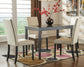 The Kimonte Rectangular Dining Room Table, paired with four beige chairs, a vase of red flowers, and a patterned rug, adds a stylish contemporary touch to this modern dining room.
