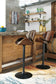 A pair of Bellatier Tall UPH Swivel Barstools with adjustable height and faux leather upholstery are placed at a rustic kitchen counter, with shelves of glassware and bottles behind them and a colorful rug on the floor.