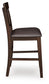 Side view of the Haddigan Upholstered Barstool (2/CN) featuring a dark brown wooden frame, slat back, cushioned faux leather seat, and convenient footrest.