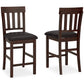 The Haddigan Upholstered Barstool (2/CN) set features two dark wood barstools with slat backs and black faux leather seats, displayed from front and side views on a white background.