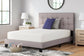 A bright, modern bedroom features a neatly made twin bed with a tufted headboard, two pillows, and nightstands with lamps. Beside the bed sits a basket of books on the floor next to the plush Chime 12 Inch Memory Foam Mattress.