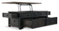 The Tyler Creek Lift Top Cocktail Table is a black wooden table with four open drawers and internal storage, combining style and function.
