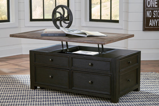 The Tyler Creek Lift Top Cocktail Table, featuring storage drawers, holds an open book and a metal wheel, and is set on a checkered rug in a bright room.