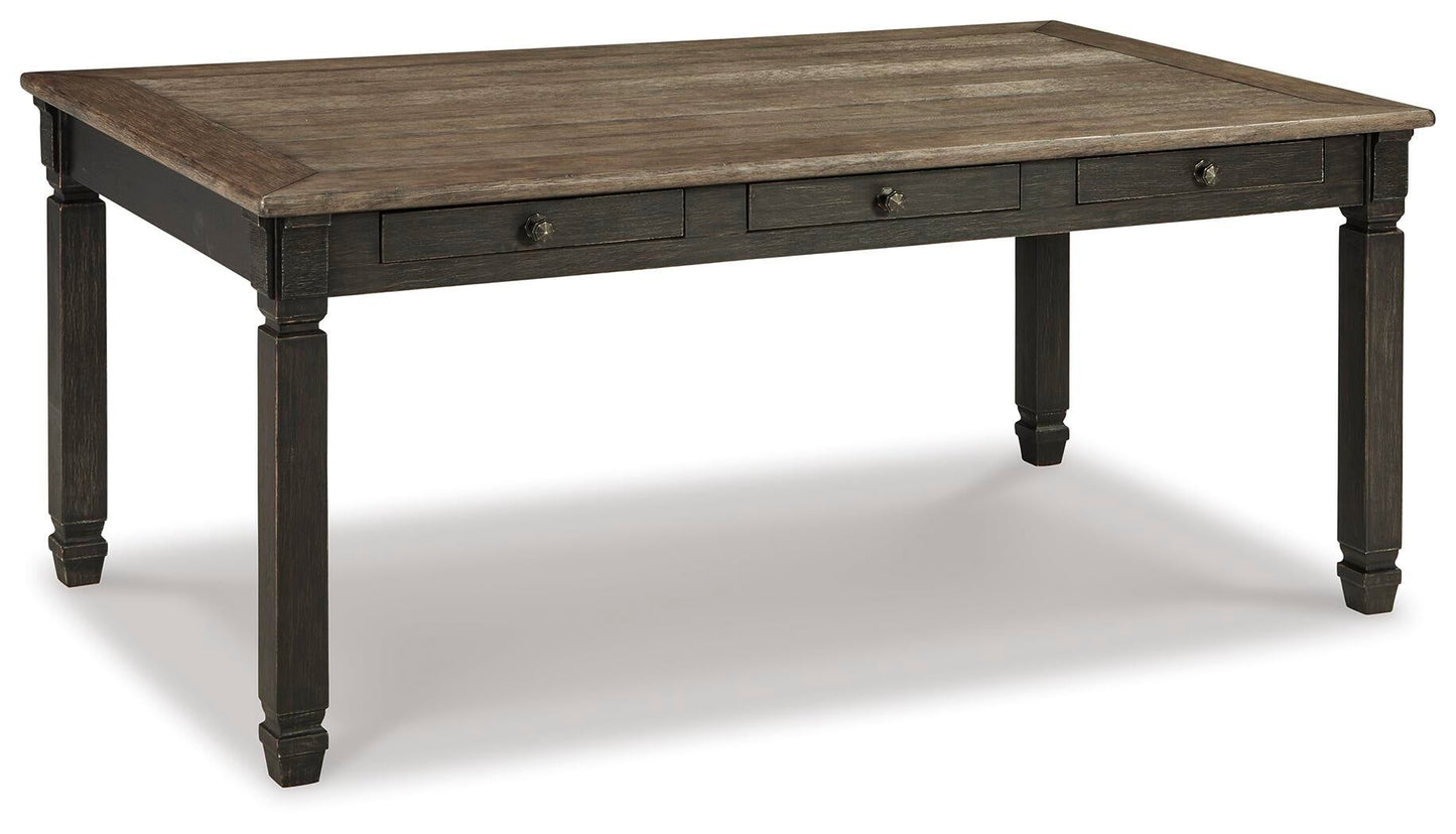 The Tyler Creek Rectangular Dining Room Table features a dark two-tone finish, four sturdy legs, and three small side drawers—ideal for urban farmhouse style spaces.
