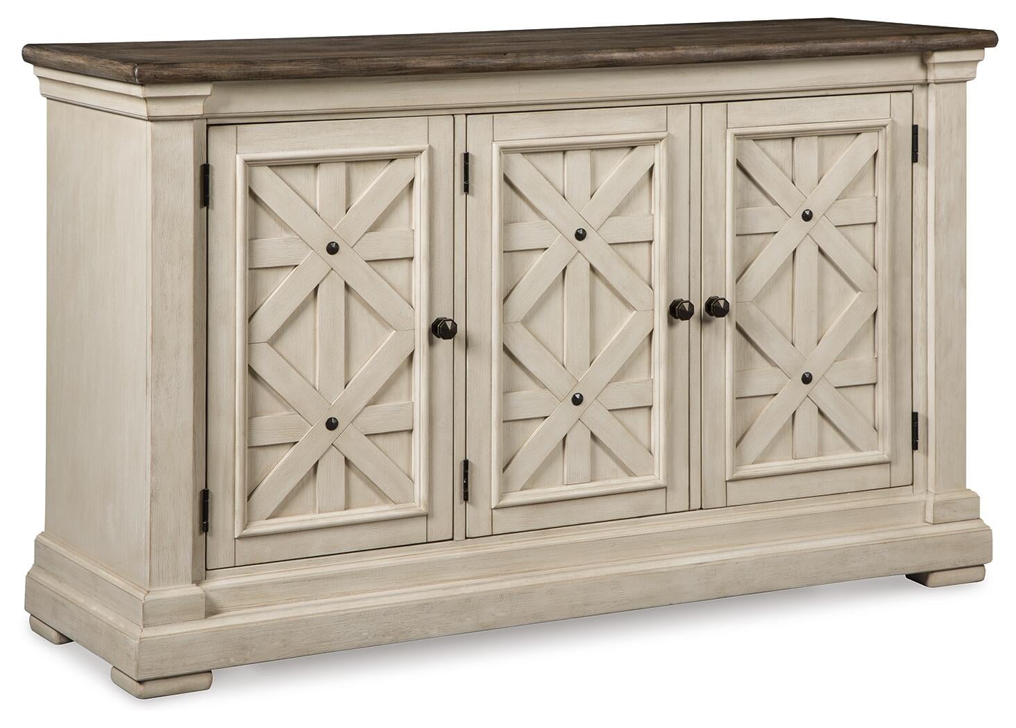 The Bolanburg Dining Room Server is a vintage-inspired wooden sideboard with a weathered oak finish, dark top, and three cream-colored paneled doors featuring a crisscross design and round knobs.