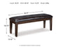 The Haddigan Large UPH Dining Room Bench features dark brown faux leather and wooden legs, ideal for dining room seating. Measures 49.75"W x 15.75"D x 18.75"H and weighs 27 lbs, with dimensions labeled around the bench.