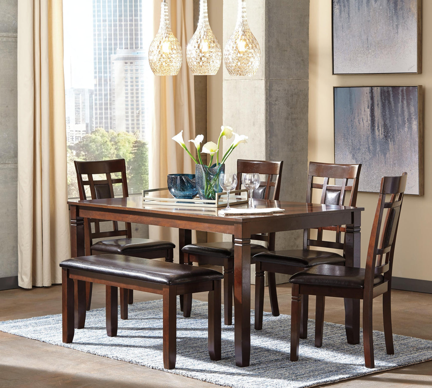 A modern dining room features the Bennox Dining Room Table Set (6/CN) with four upholstered chairs, a bench, and place settings. Pendant lights, abstract art, and large windows create an inviting atmosphere.