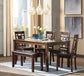 A modern dining room features the Bennox Dining Room Table Set (6/CN) with four upholstered chairs, a bench, and place settings. Pendant lights, abstract art, and large windows create an inviting atmosphere.