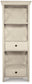 The Bolanburg Display Cabinet boasts an antiqued white finish, two open shelves, and two drawers with black knobs—perfect as a charming cottage-style addition to your space.