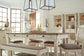 A bright dining room features the Bolanburg Rectangular Dining Room Table with six chairs, a bench, pendant lights, shelves displaying decor and dishes, plus a vase with branches and wine bottles on the table.