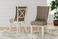 Two Bolanburg Dining UPH Side Chairs with cushioned seats and light wood frames in an antiqued white finish sit on a patterned rug in a bright room with white shiplap walls and a potted plant.