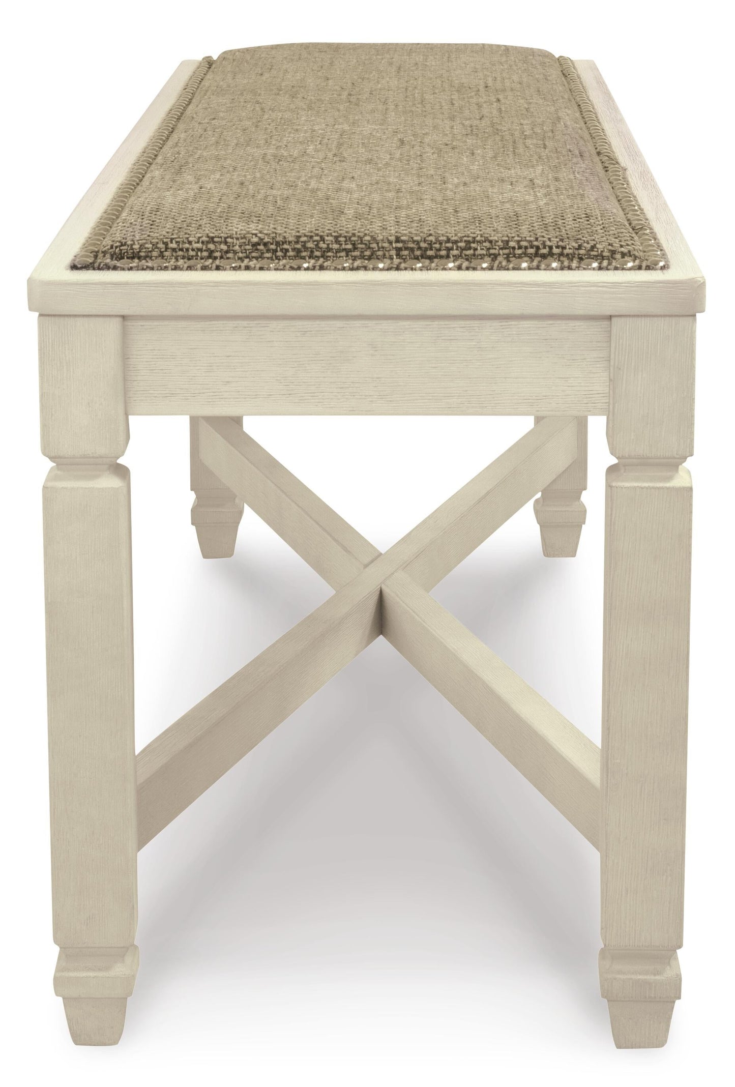 The Bolanburg Large UPH Dining Room Bench features a rectangular wooden frame, cross-braced legs in antiqued white, and a cushioned seat with beige heavy woven upholstery, shown from the front.