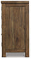 Side view of the Moriville Dining Room Server, featuring a distressed nutmeg finish, visible wood grain, antiqued bronze-tone hardware, and a simple rectangular frame.
