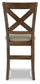 The Moriville Upholstered Barstool (2/CN) features an X-shaped backrest and decorative nailhead trim, shown from the back against a white background.