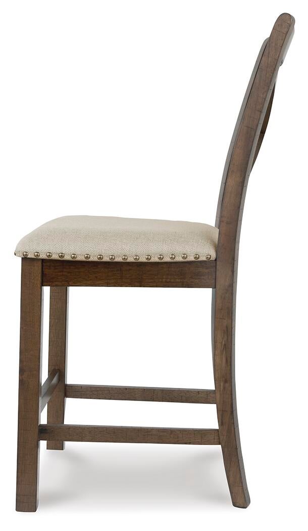 Side view of the Moriville Upholstered Barstool (2/CN) featuring a padded light-colored seat, decorative nailhead trim, and a wooden frame in a distressed nutmeg finish.