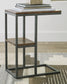 The Forestmin Accent Table features a black metal frame and rustic wood surfaces, topped with a stack of books, and sits elegantly on a patterned rug, adding minimalist-chic style to any space.