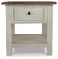 The Bolanburg Rectangular End Table has a two-tone distressed finish with a dark brown top and light gray base, a single smooth-gliding drawer with black knob, and an open lower shelf for added storage.