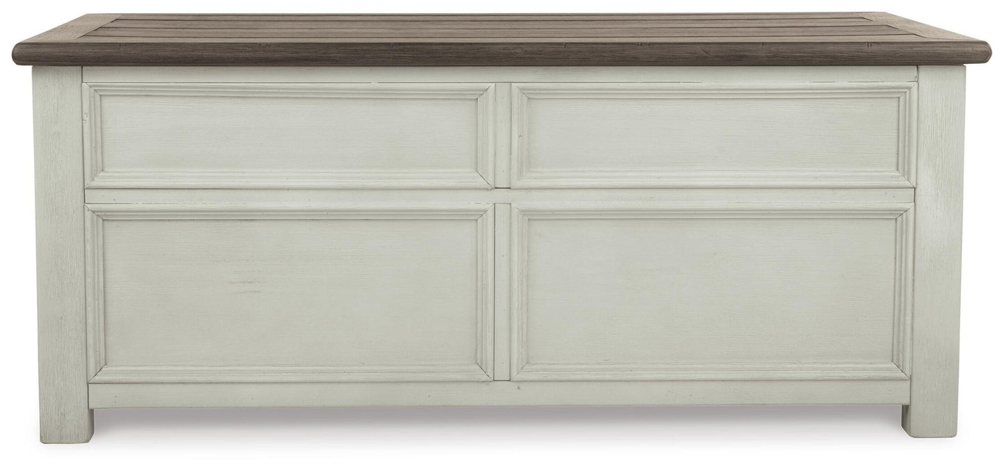 The Bolanburg Lift Top Cocktail Table features a dark brown top, antique white finish, stylish paneled front, and convenient storage drawers.