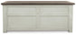 The Bolanburg Lift Top Cocktail Table features a dark brown top, antique white finish, stylish paneled front, and convenient storage drawers.
