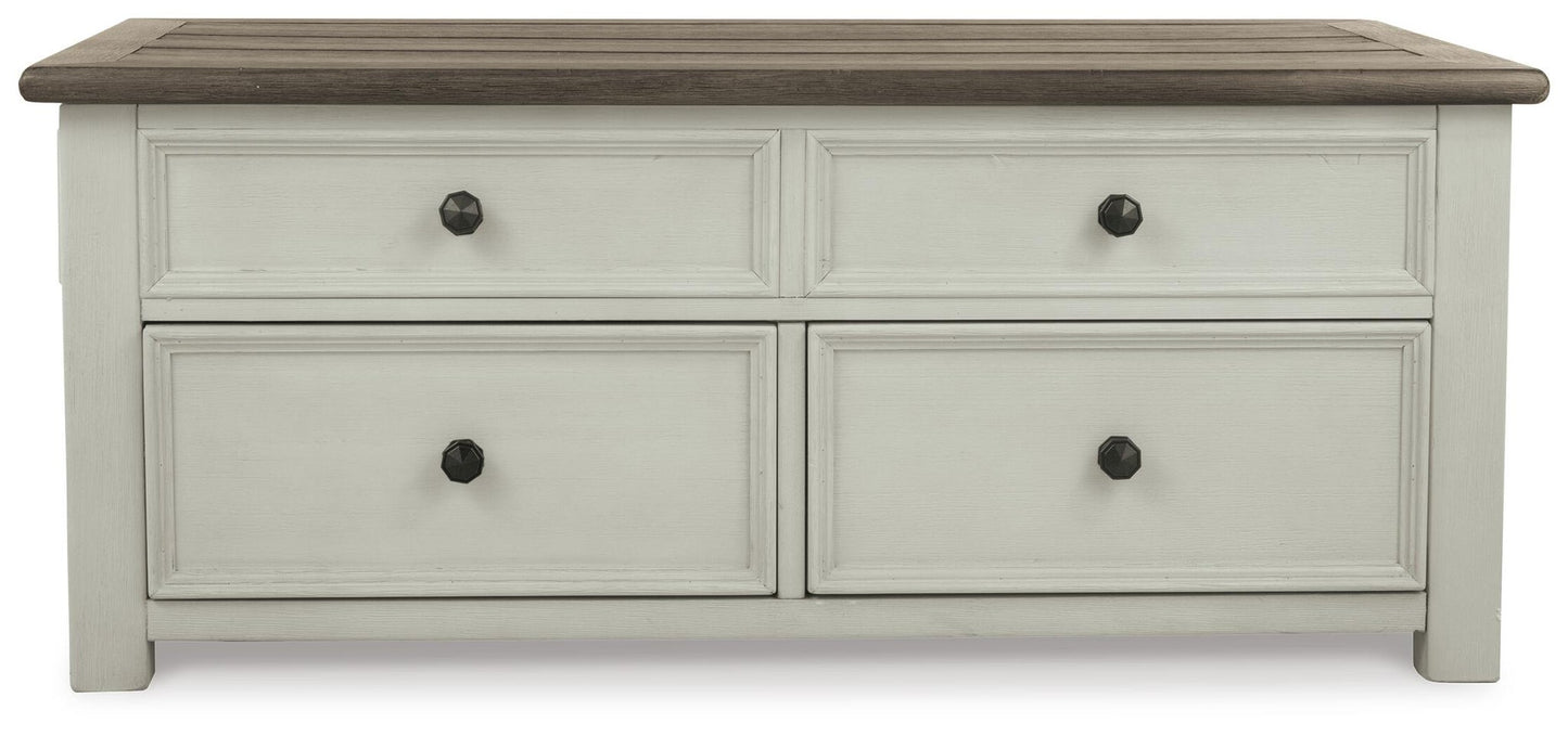 The Bolanburg Lift Top Cocktail Table features a dark wood top, four drawers with black round knobs, and an antique white body finish—offering both storage and charm to any room.